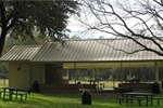 A covered patio with a bathroon and trashcans